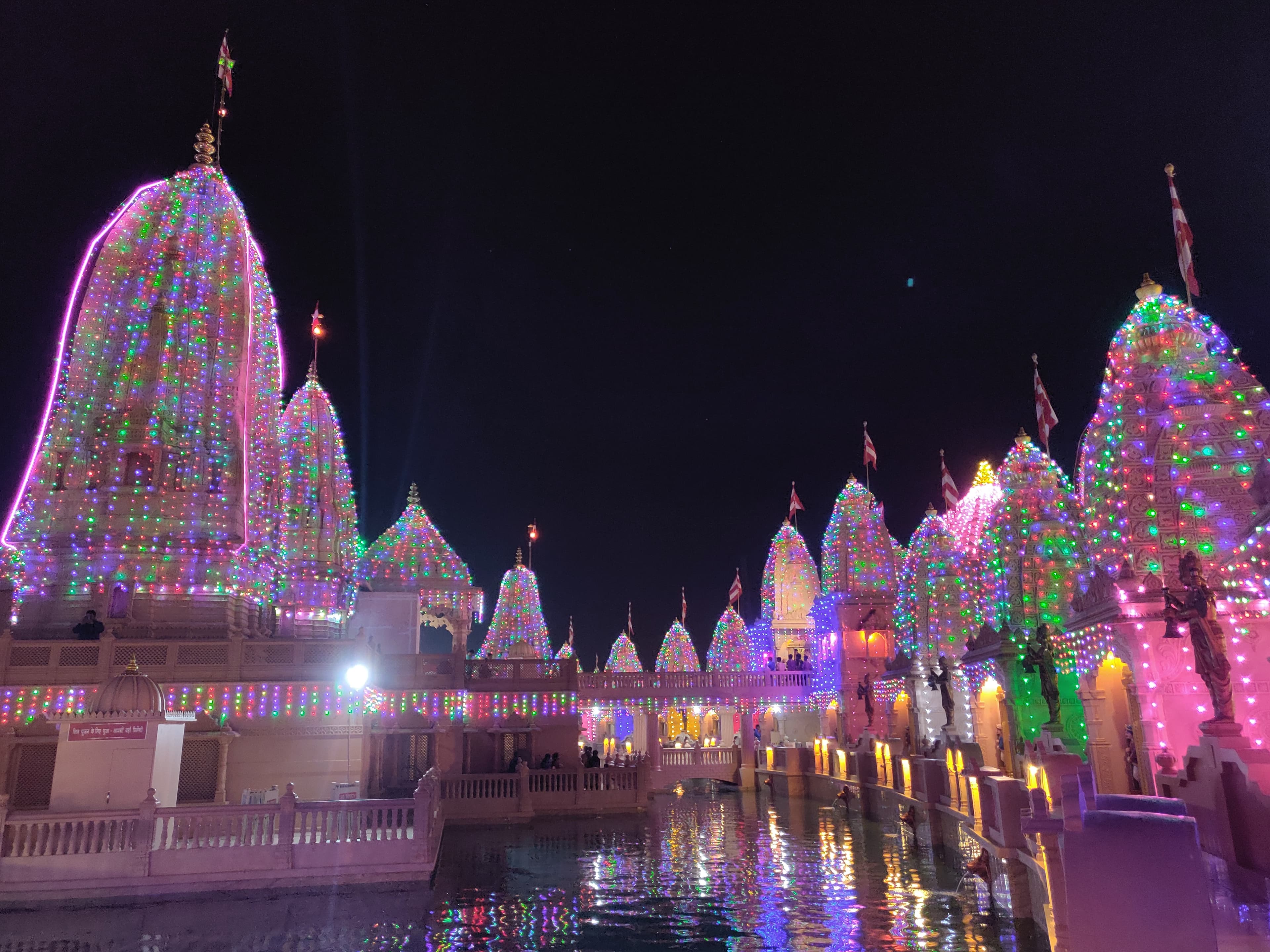 The midday sun beat down on the sprawling complex of Nilkanth Dham Swami Narayan Temple in Poicha, Gujarat, its reflection shimmering off the intricate carvings that adorned every surface. Stepping t...